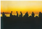 Menschengruppe im Sonnenuntergang am Wasser