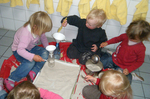 Kinder füllen im Waschraum Sand in Flaschen