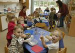 Kinder sitzen an Tischen und essen