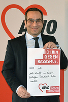 Rifat Fersahoglu-Weber hält ein Plakat mit der Aufschrift: "Ich bin gegen Rassismus, weil ich auch zukünftig in einem weltoffenen Deutschland leben möchte."