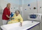 Eine Pflegerin und eine Bewohnerin bereiten ein Bad in der Badewanne vor