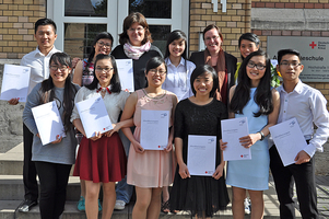 Zehn junge Leute aus Vietnam präsentieren ihre Zertifikate, hinter ihnen stehen zwei weitere Frauen.
